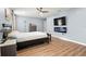Main bedroom with wood-look flooring, fireplace, and TV; light and airy at 1726 Hadden Hall Pl, Trinity, FL 34655