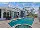 Pool and spa in the backyard with an enclosed screen, complemented by lush landscaping at 18107 Sugar Brooke Dr, Tampa, FL 33647
