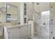 Modern bathroom with a white vanity, elegant mirrors, and a glass-enclosed shower at 18107 Sugar Brooke Dr, Tampa, FL 33647