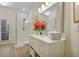 All-white bathroom featuring a modern vanity, large mirror, and glass-enclosed shower with bright natural light at 18107 Sugar Brooke Dr, Tampa, FL 33647