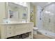 Light-filled bathroom with double sink vanity, decorative mirror, and glass shower at 18107 Sugar Brooke Dr, Tampa, FL 33647