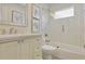 Bright bathroom with a tub-shower combo with glass door, floral art, and tile accent wall at 18107 Sugar Brooke Dr, Tampa, FL 33647