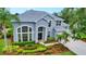 Charming two-story home with arched windows, a two-car garage, and mature landscaping at 18107 Sugar Brooke Dr, Tampa, FL 33647