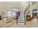 Bright foyer features a curved staircase with iron railings and an adjacent seating area at 18107 Sugar Brooke Dr, Tampa, FL 33647