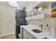 Chic laundry room features a gray stacked washer/dryer unit and a counter with stylish shelving at 18107 Sugar Brooke Dr, Tampa, FL 33647