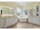 Bright primary bath with dual vanities, soaking tub, and stylish fixtures in a modern, neutral design at 18107 Sugar Brooke Dr, Tampa, FL 33647