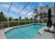 Screened-in pool area with a beautiful blue pool, and relaxing backyard views at 18107 Sugar Brooke Dr, Tampa, FL 33647
