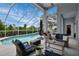 A covered lanai with an outdoor living space overlooks a sparkling pool and lush landscaping at 18107 Sugar Brooke Dr, Tampa, FL 33647