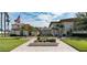 Exterior community view featuring manicured landscaping, palm trees, and elegant buildings with tile roofs at 19029 Us Highway 19 N # 31F, Clearwater, FL 33764