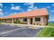 Waterfront condominium features a terracotta tile roof, assigned parking, and mature landscaping at 19029 Us Highway 19 N # 31F, Clearwater, FL 33764