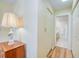 Hallway view leading to a full bathroom, featuring a lamp and additional closet storage at 19029 Us Highway 19 N # 31F, Clearwater, FL 33764