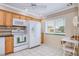 Eat-in kitchen showcases a tile floor, white appliances, and ample cabinet space at 19029 Us Highway 19 N # 31F, Clearwater, FL 33764