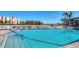 Community pool with clear water and a backdrop of palm trees and multi-story condo buildings at 19029 Us Highway 19 N # 31F, Clearwater, FL 33764