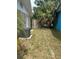 Cozy backyard space featuring an AC unit, wood fence and mature landscaping at 2075 Plateau Rd, Clearwater, FL 33755
