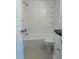 Bathroom with a combined tub and shower, white tile surround, and built-in shelving at 2075 Plateau Rd, Clearwater, FL 33755