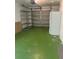 Spacious garage offering ample storage with shelving, a refrigerator, and epoxy floor at 2075 Plateau Rd, Clearwater, FL 33755