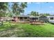 Wide backyard with an open lawn, a hammock, and a large wooden deck with outdoor furniture at 2122 W Ferris Ave, Tampa, FL 33603