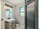 Cozy bathroom featuring modern vanity, framed mirror, and glass door shower with blue subway tile at 2122 W Ferris Ave, Tampa, FL 33603