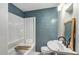Bathroom with white tub/shower and a sink with dark wood cabinet and backsplash at 2122 W Ferris Ave, Tampa, FL 33603