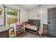 Bright bedroom with a gray crib, a window, and a gray accent wall at 2122 W Ferris Ave, Tampa, FL 33603