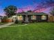 Charming home showcasing a well-manicured lawn, fresh landscaping, and inviting curb appeal at sunset at 2122 W Ferris Ave, Tampa, FL 33603