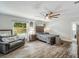Bright main bedroom with rustic wood floors, a ceiling fan, a bed, and views to the backyard at 2122 W Ferris Ave, Tampa, FL 33603