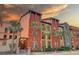 Exterior building view showcasing colorful facade, balconies, and lush palm trees at sunset at 2402 Azeele W St # 412, Tampa, FL 33609