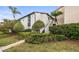 Charming exterior view of a two-story home with lush landscaping and mature trees at 2597 Countryside Blvd # 206, Clearwater, FL 33761