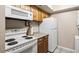 Compact kitchen features a white range, white refrigerator and stacked washer/dryer at 2597 Countryside Blvd # 206, Clearwater, FL 33761