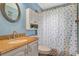 Cozy bathroom with a round mirror, granite vanity, and tub with a shower curtain showcasing butterfly designs at 2816 Manor Hill Dr, Brandon, FL 33511