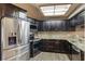 Well-lit kitchen with dark cabinets, stainless steel appliances, and a stylish backsplash at 2816 Manor Hill Dr, Brandon, FL 33511