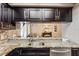 Updated kitchen with granite countertops, stainless steel sink, and view into the living area at 2816 Manor Hill Dr, Brandon, FL 33511