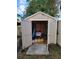 Storage shed with double doors open revealing neatly organized tools and lawn care supplies at 2816 Manor Hill Dr, Brandon, FL 33511