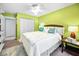 Bright bedroom with vibrant green walls, ceiling fan, and a comfortable queen-sized bed with stylish accent pillows at 300 S Florida Ave # 200J, Tarpon Springs, FL 34689