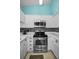 Bright kitchen with stainless steel oven and microwave appliances plus white cabinets and mosaic backsplash at 300 S Florida Ave # 200J, Tarpon Springs, FL 34689