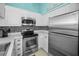 Open kitchen with white cabinets, stainless appliances, mosaic backsplash, and beachy themed decorations at 300 S Florida Ave # 200J, Tarpon Springs, FL 34689
