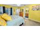 Bright main bedroom with ceiling fan, large windows, walk-in closet, ensuite bathroom, and beachy decor at 300 S Florida Ave # 200J, Tarpon Springs, FL 34689