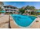 Large community pool surrounded by lush landscaping, adjacent to a modern condominium complex at 300 S Florida Ave # 200J, Tarpon Springs, FL 34689