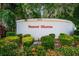 Elegant community entrance sign for Sunset Shores, set amidst lush landscaping and colorful flowers at 300 S Florida Ave # 200J, Tarpon Springs, FL 34689