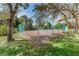 Fenced tennis court surrounded by lush greenery and mature trees providing a private recreational space at 300 S Florida Ave # 200J, Tarpon Springs, FL 34689