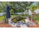 A decorative backyard pond with landscaping, rocks, and a small water feature under large trees at 308 Jeanal Pl, Tampa, FL 33612