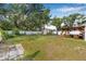 Large backyard with green lawn, shed, water feature, white fencing and covered patio at 308 Jeanal Pl, Tampa, FL 33612