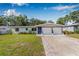 Charming single-story home featuring brick accents, a blue front door, and a well-maintained lawn at 308 Jeanal Pl, Tampa, FL 33612