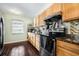Efficient kitchen with wood cabinets, dark countertops, stainless steel appliances and wood-look tile flooring at 308 Jeanal Pl, Tampa, FL 33612