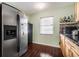 Bright kitchen with stainless steel refrigerator, wood cabinets, dark countertops and wood-look tile flooring at 308 Jeanal Pl, Tampa, FL 33612
