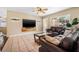 Inviting living room with tile floors, a ceiling fan, a large window, and comfortable leather furniture at 308 Jeanal Pl, Tampa, FL 33612