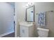 A bathroom with white cabinets, gray framed mirror, seashell decor, and a decorative towel at 3122 Christophers Watch Ln, Ruskin, FL 33570