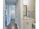 Hallway leading to a bathroom with white cabinets, a vanity, and decorative towel at 3122 Christophers Watch Ln, Ruskin, FL 33570