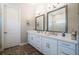 Spacious bathroom with dual sinks, white cabinets, modern fixtures, and a large framed mirror at 3122 Christophers Watch Ln, Ruskin, FL 33570