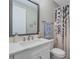 Bathroom with white vanity, gray framed mirror, seashell decor, and patterned shower curtain at 3122 Christophers Watch Ln, Ruskin, FL 33570